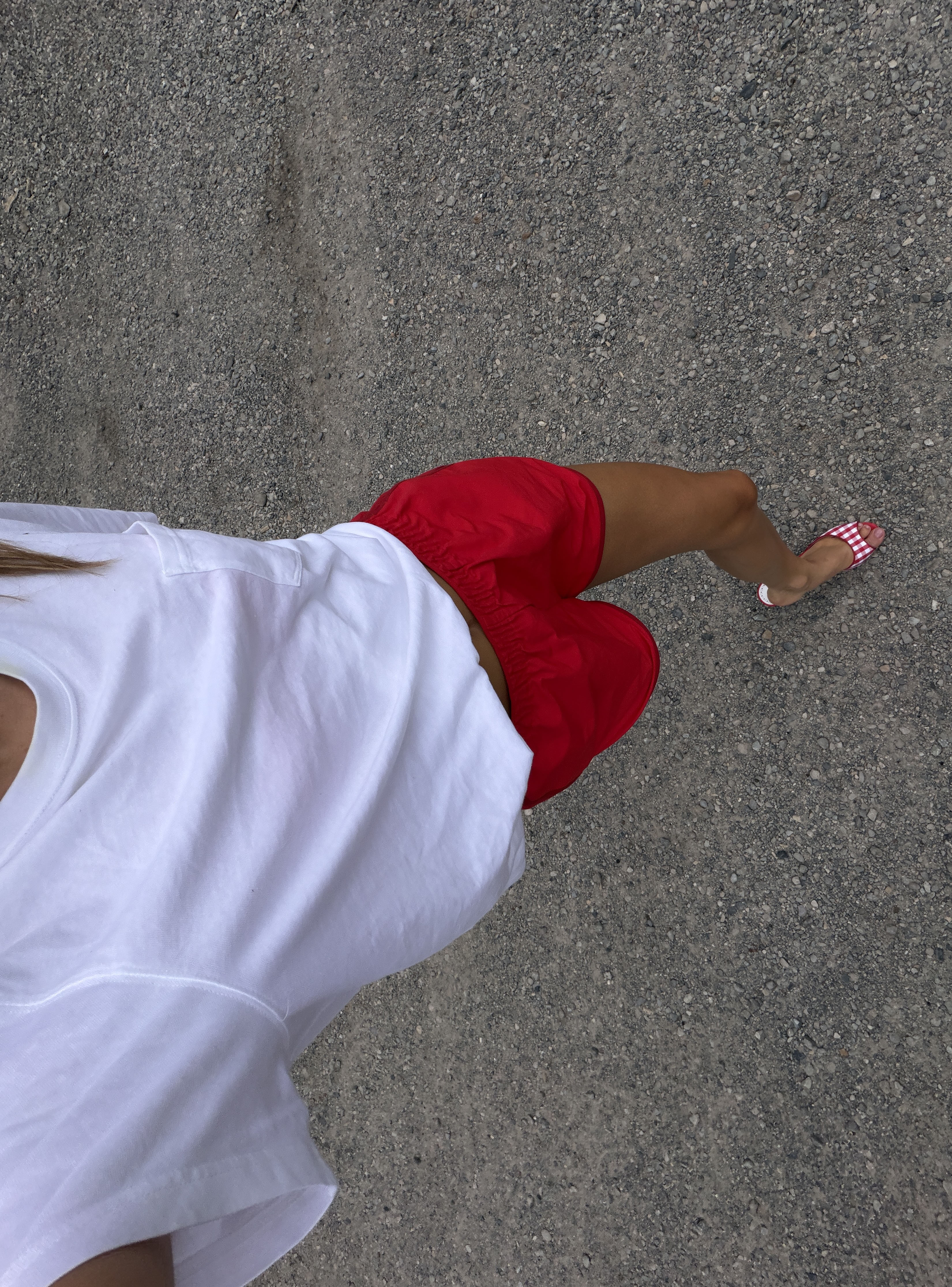 Woman in a white tee and red shorts.