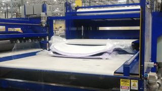 Mattress in a box being compressed by machine in 3Z Brands mattress factory