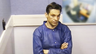 A still from police interrogation footage used in The British Airways Killer shows Robert Brown sitting with his arms crossed