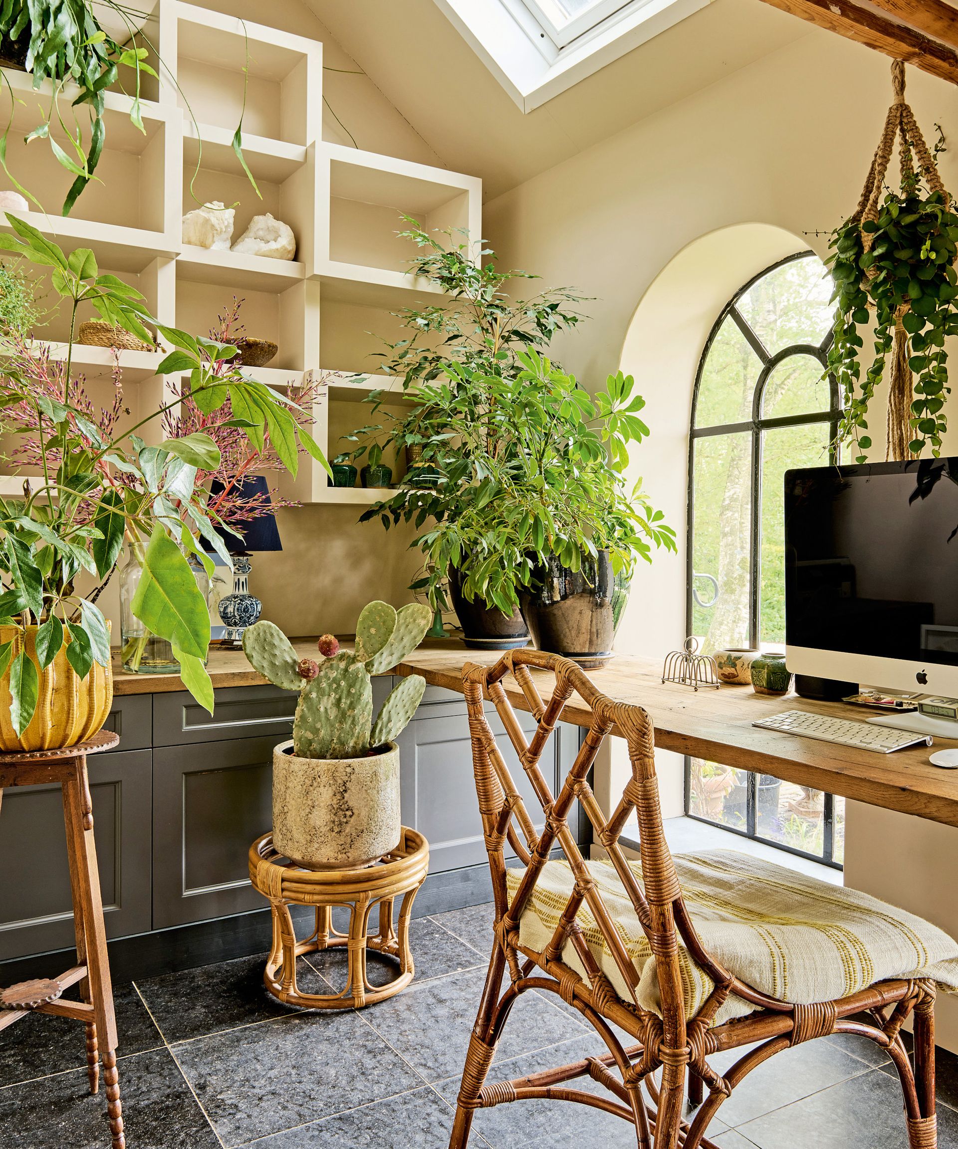 neutral office with cane furniture, cream shelving and dark gray cabinetry