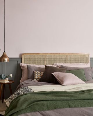 pink paint color on bedroom wall with olive green wood paneling on the lower half of the wall behind the bed