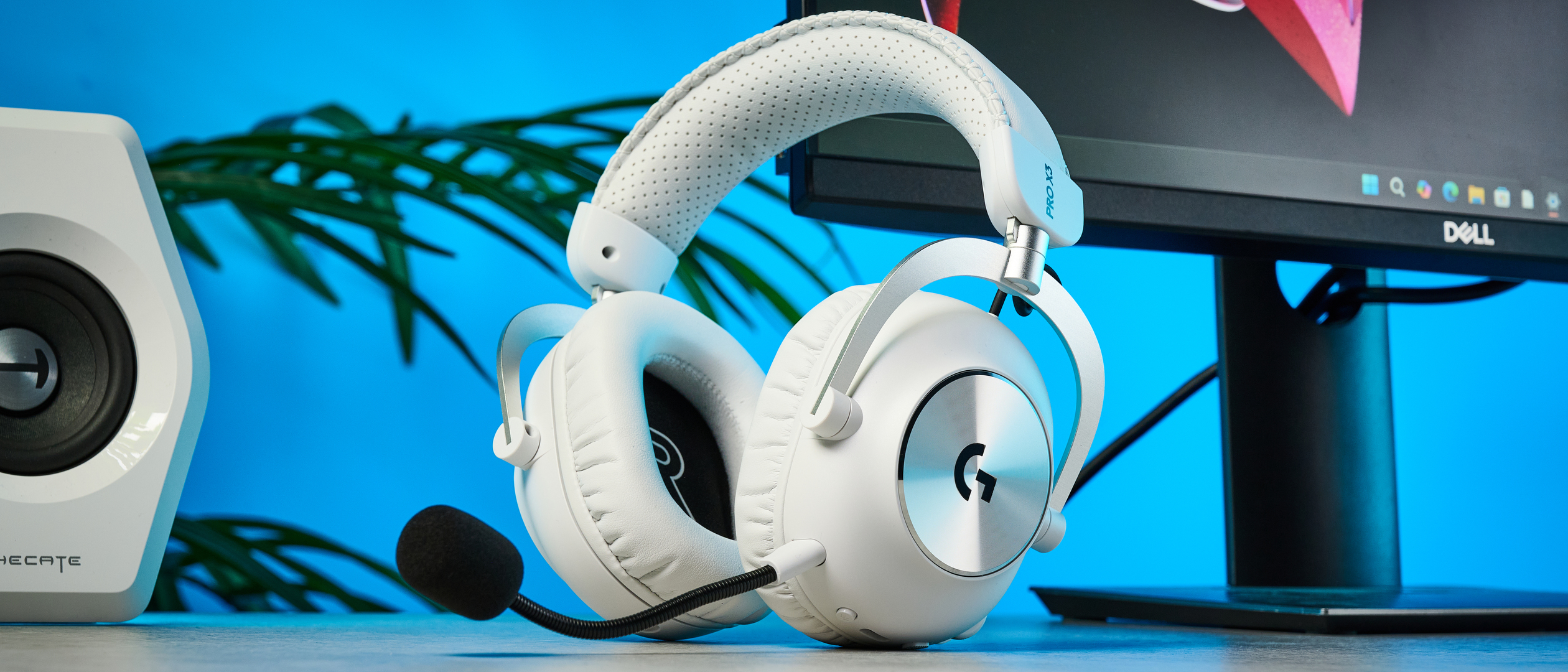 The Logitech G Pro X3 Lightspeed headset in white, on a stone surface.