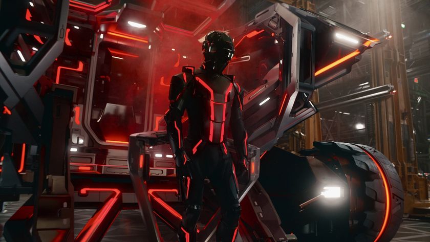 A person wearing a Tron suit stands in front of a vehicle in a warehouse