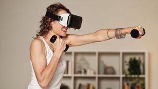 A woman uses a VR headset to help with her workout