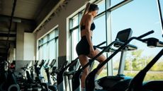 Woman using stair climber machine in gym