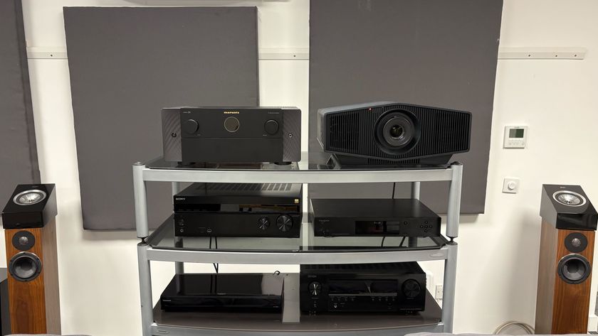 A rack with a projector, three amplifiers and two Blu-ray players on it