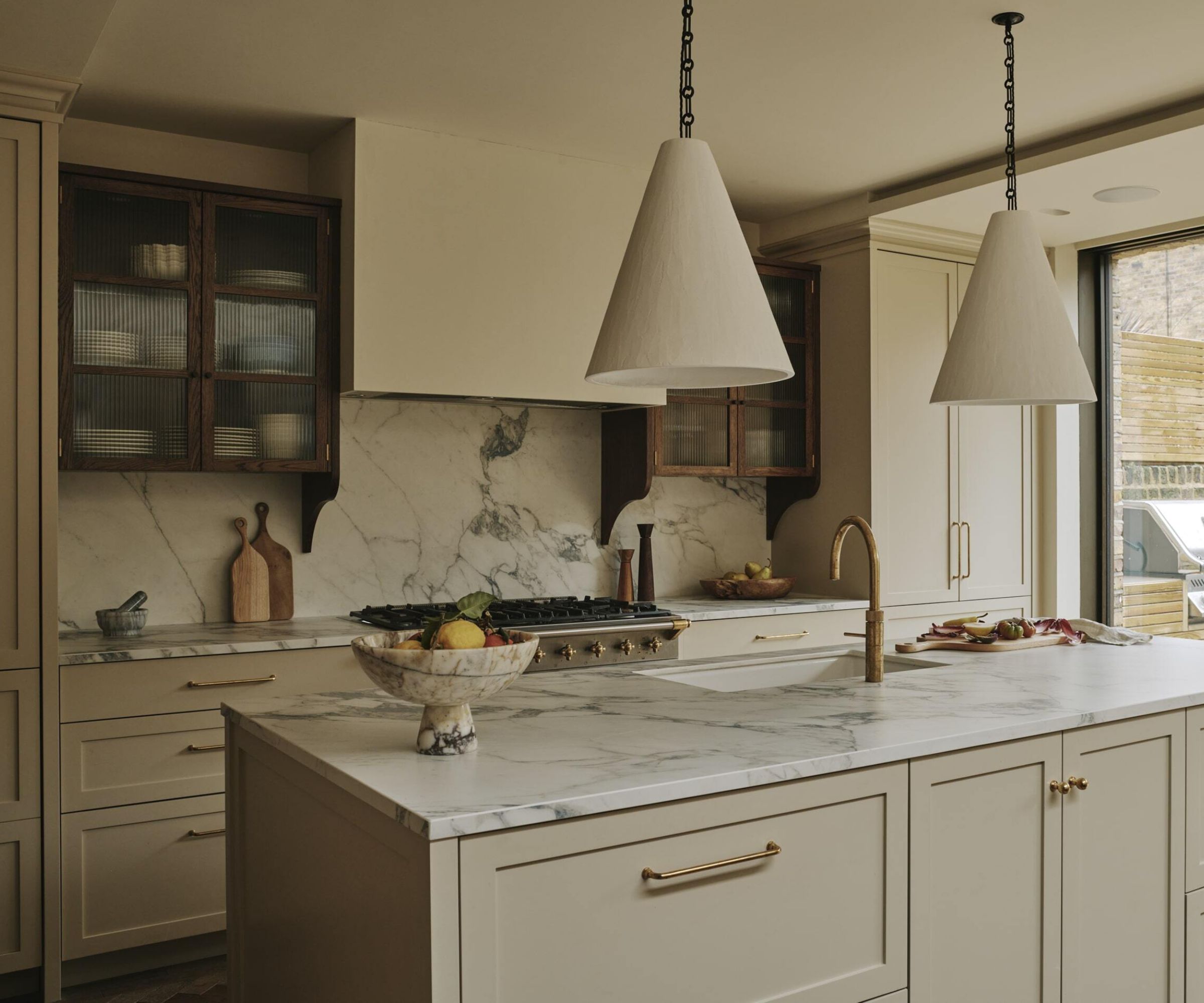 A greige kitchen with marble countertops