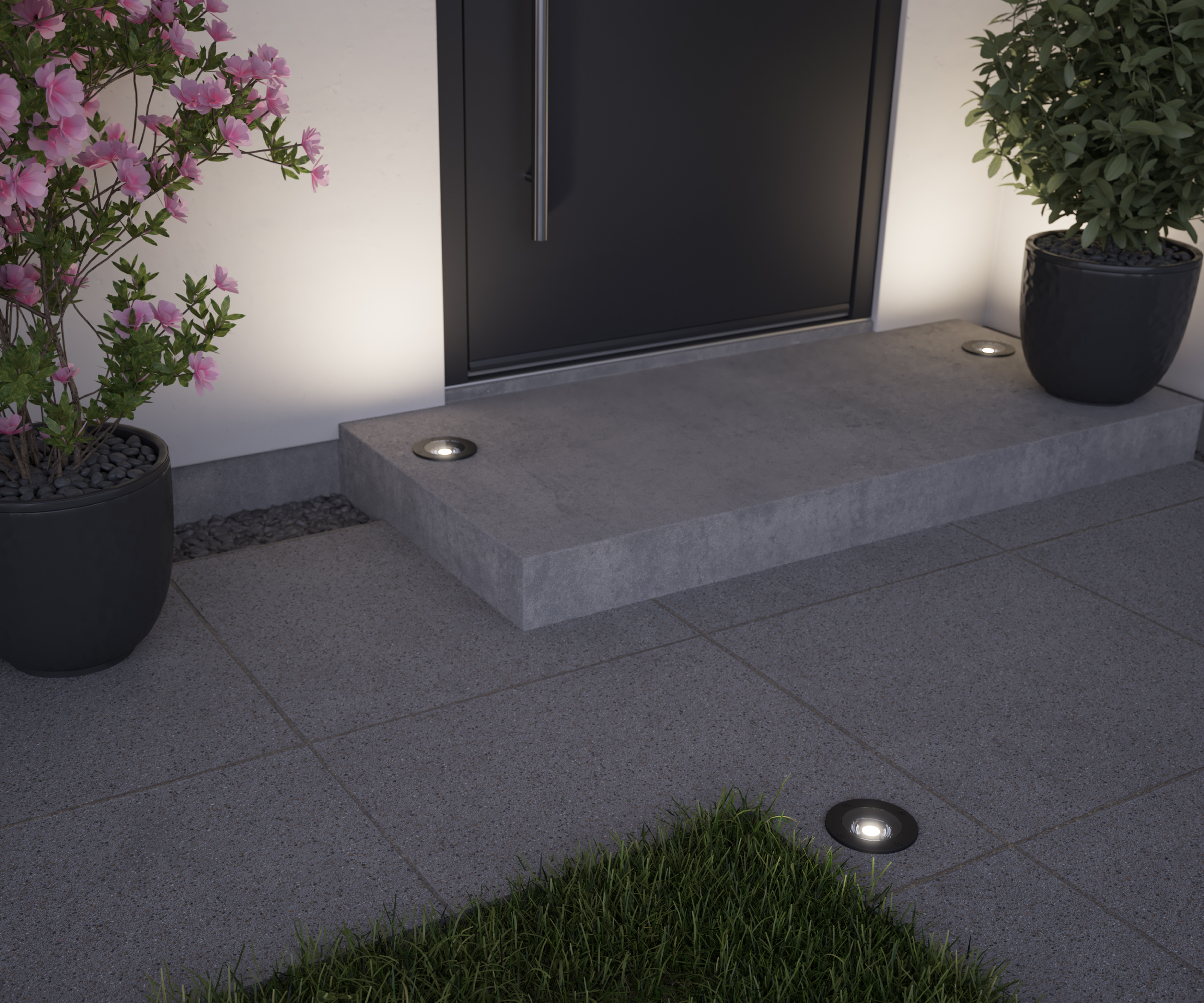 low level shot of grey paving slabs and step leading to front door with small floorlights set in slabs and on step