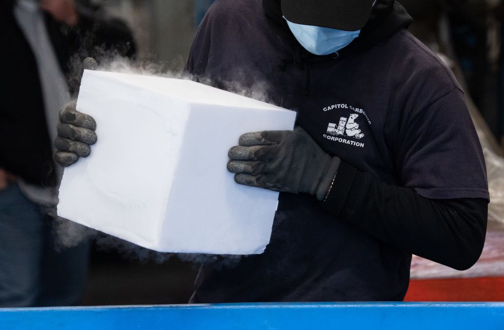 Person carrying freezing Pfizer vaccines.