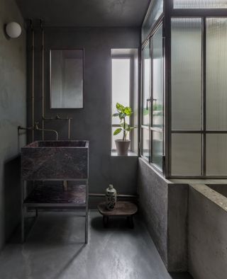 A bathroom with a freestanding basin in the corner