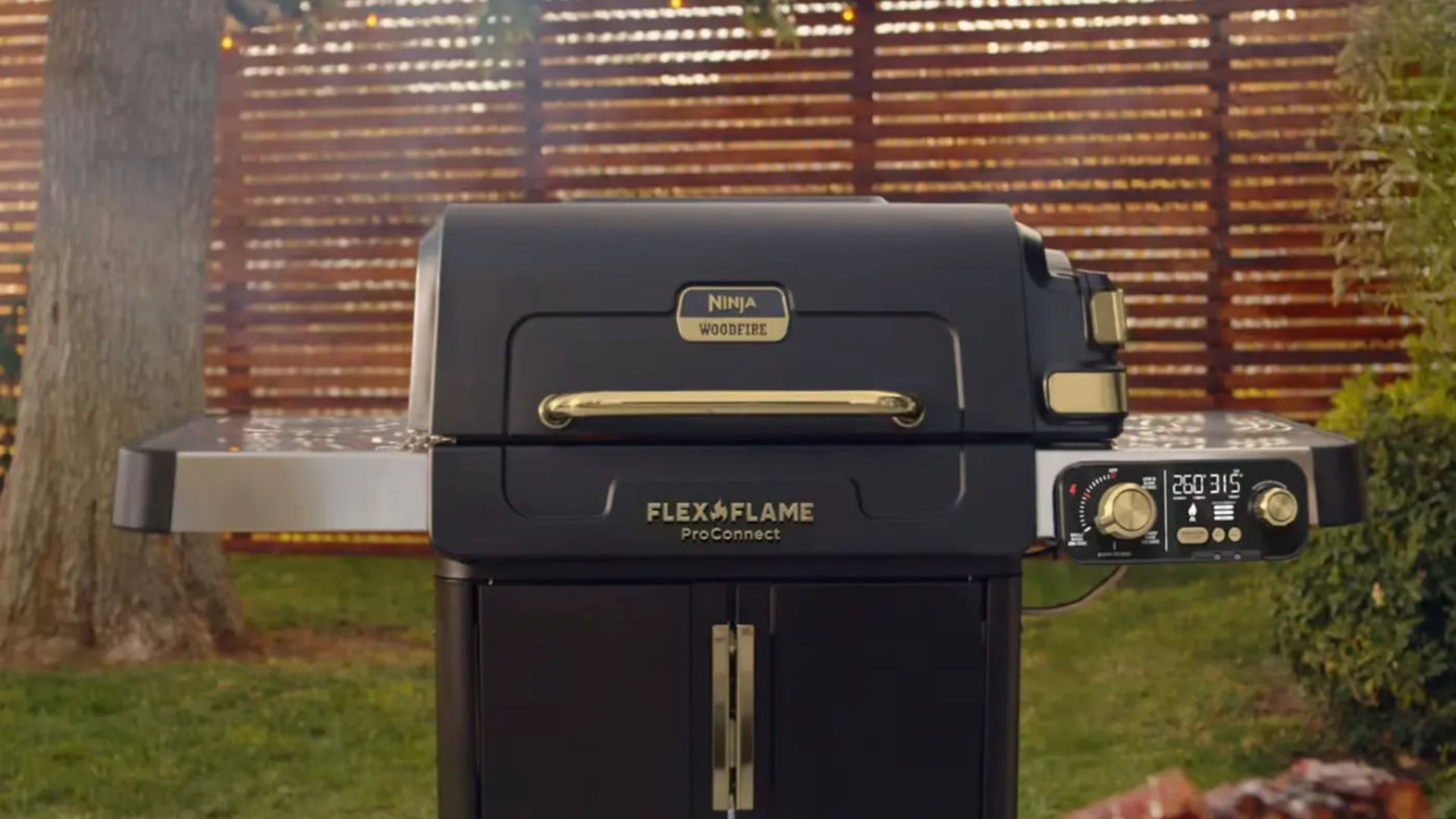Ninja FlexFlame Gas BBQ and Outdoor Cooking System with the lid closed, in a garden
