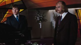 Bruce Glover and Putter Smith standing together at a funeral in Diamonds Are Forever.