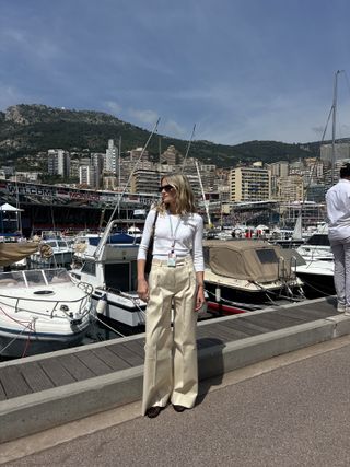 Eliza Huber wearing a white sweater and tan Proenza Schouler pants at the Monaco Grand Prix.