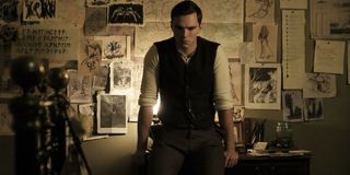 Tolkien Nicholas Hoult sits on the edge of his desk, thinking