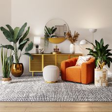 Living room home decor with orange armchair and a circular mirror