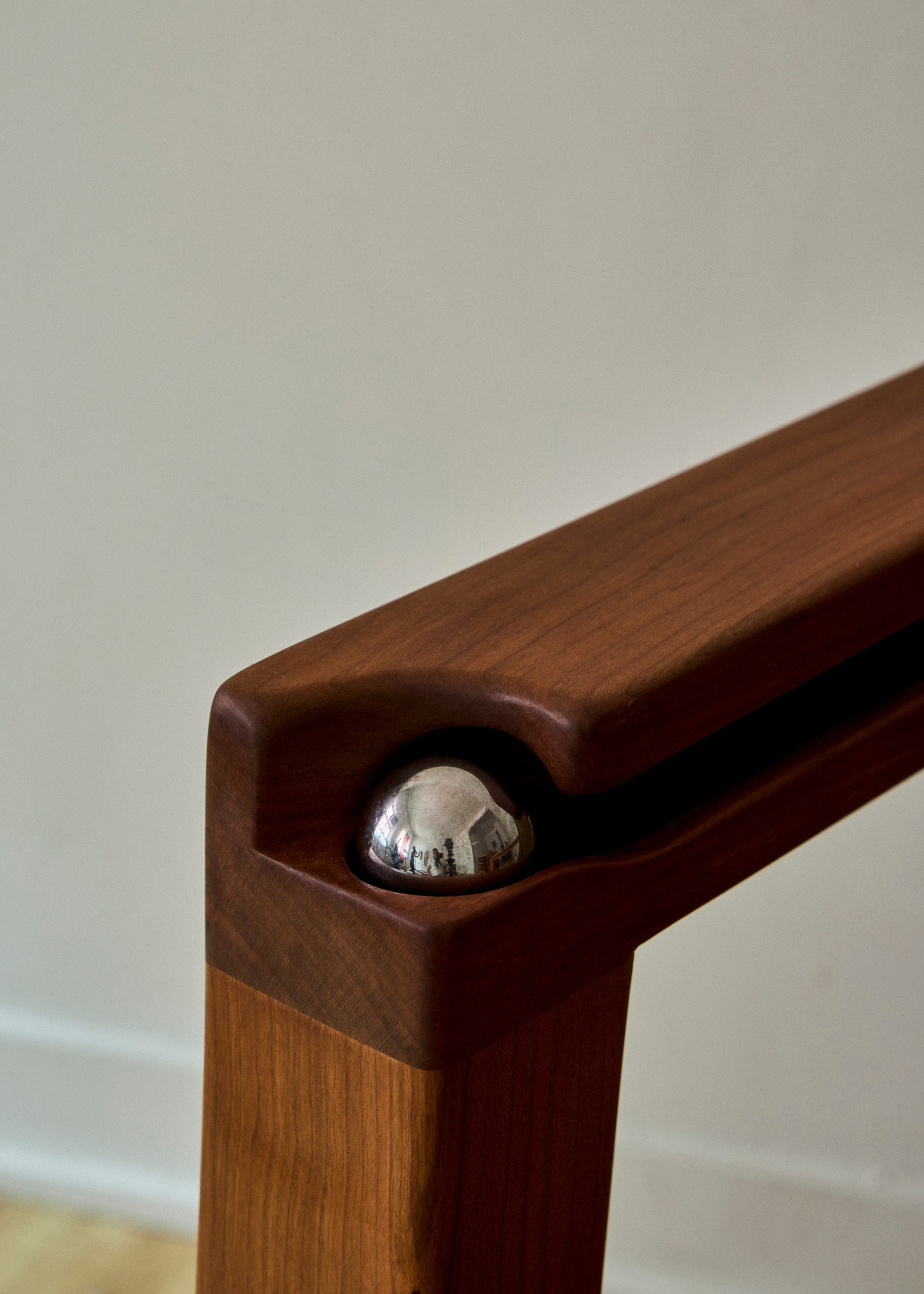 A metal ball in the corner of a wood armchair