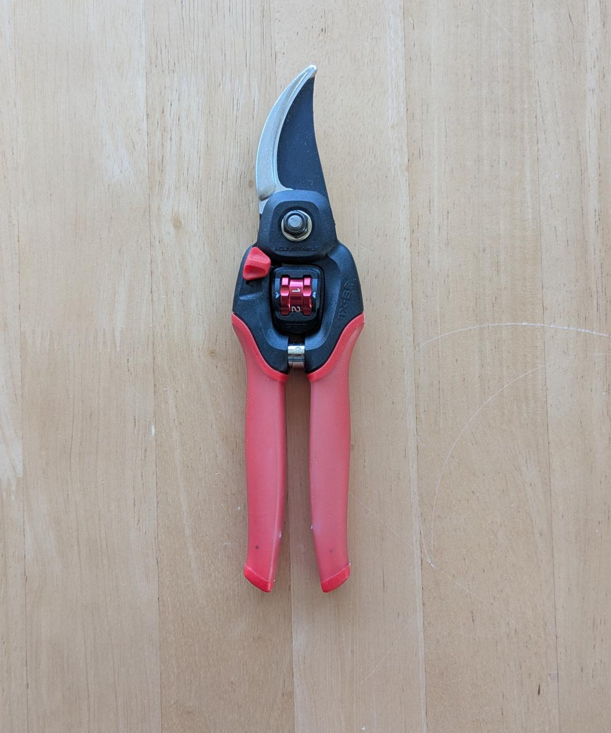 A pair of Corona FlexDIAL ComfortGEL Bypass Pruners on a wooden table