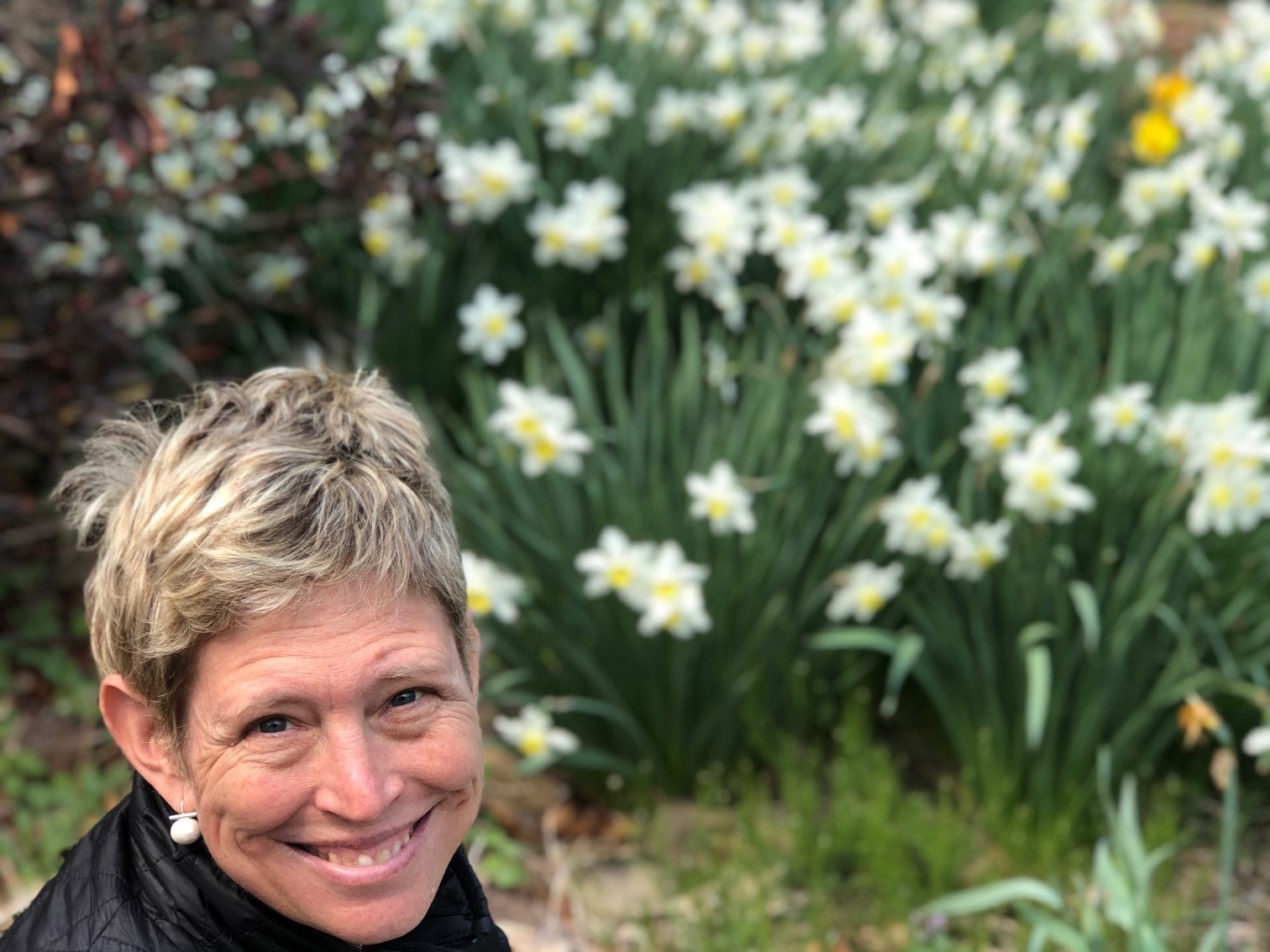 Caitlin Boyle, Dirt Diva Designs in front of daffodils
