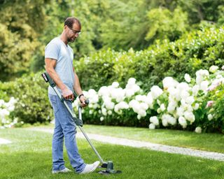 trimming a lawn with the Bosch UniversalGrassCut 18–26 cordless strimmer