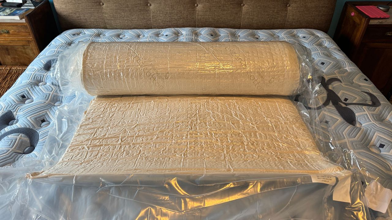 Naturepedic Adagio 2" Organic Latex Mattress Topper half-rolled in its plastic wrapping
