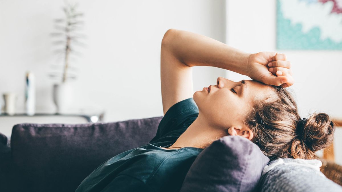 anxious young woman sat on her sofa