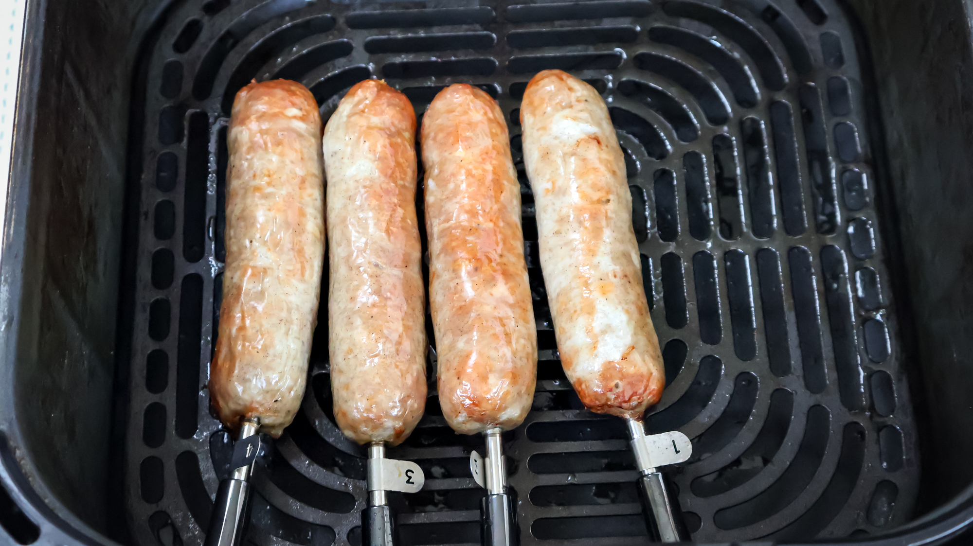 GoveeLife Smart Wireless Meat Thermometer probes inserted in sausages while cooking