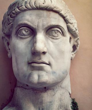 The face of the Roman christian emperor Constantine, shown in a stone statue.