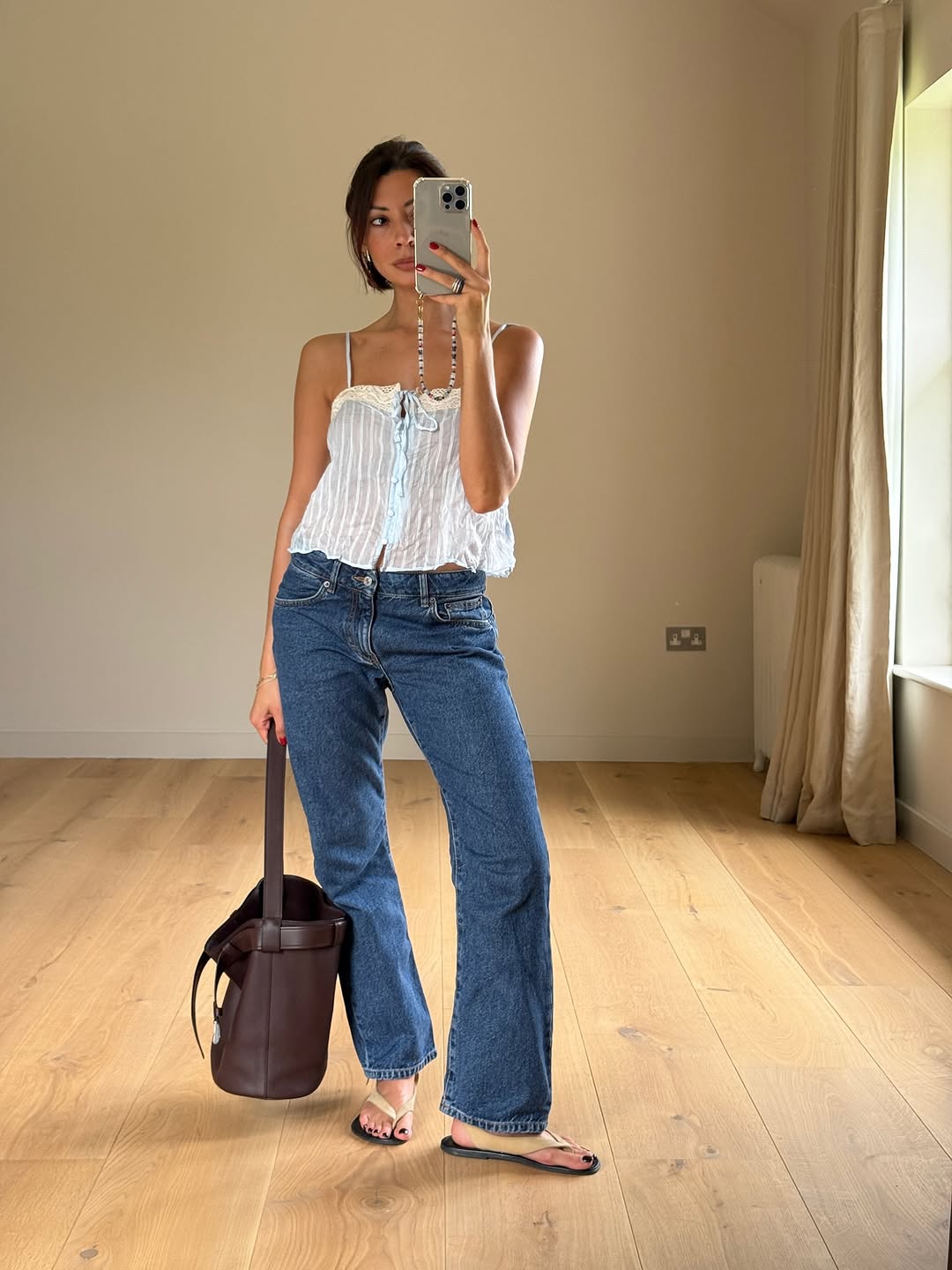 Woman wearing dark wash bootcut jeans fall 2025.