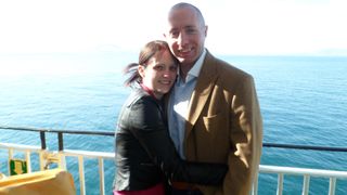 Sarah and Dan standing on a boat with sea behind them