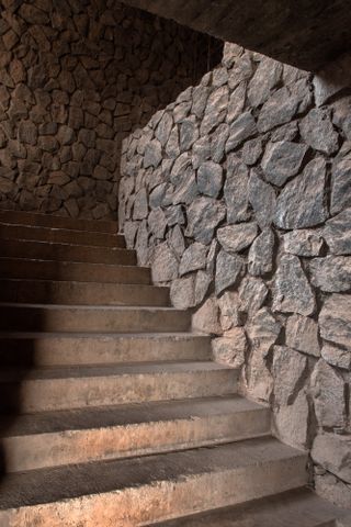 Image of stone steps surrounded by a rustic stone wall and ceiling