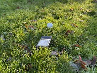 The PRGR launch monitor sat behind a golf ball in grass