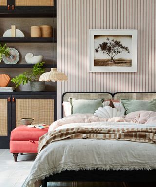 Eclectic bedroom with organic textures, striped walls and rattan bed frame