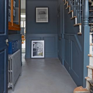 Navy blue hallway with artwork on wall and floor