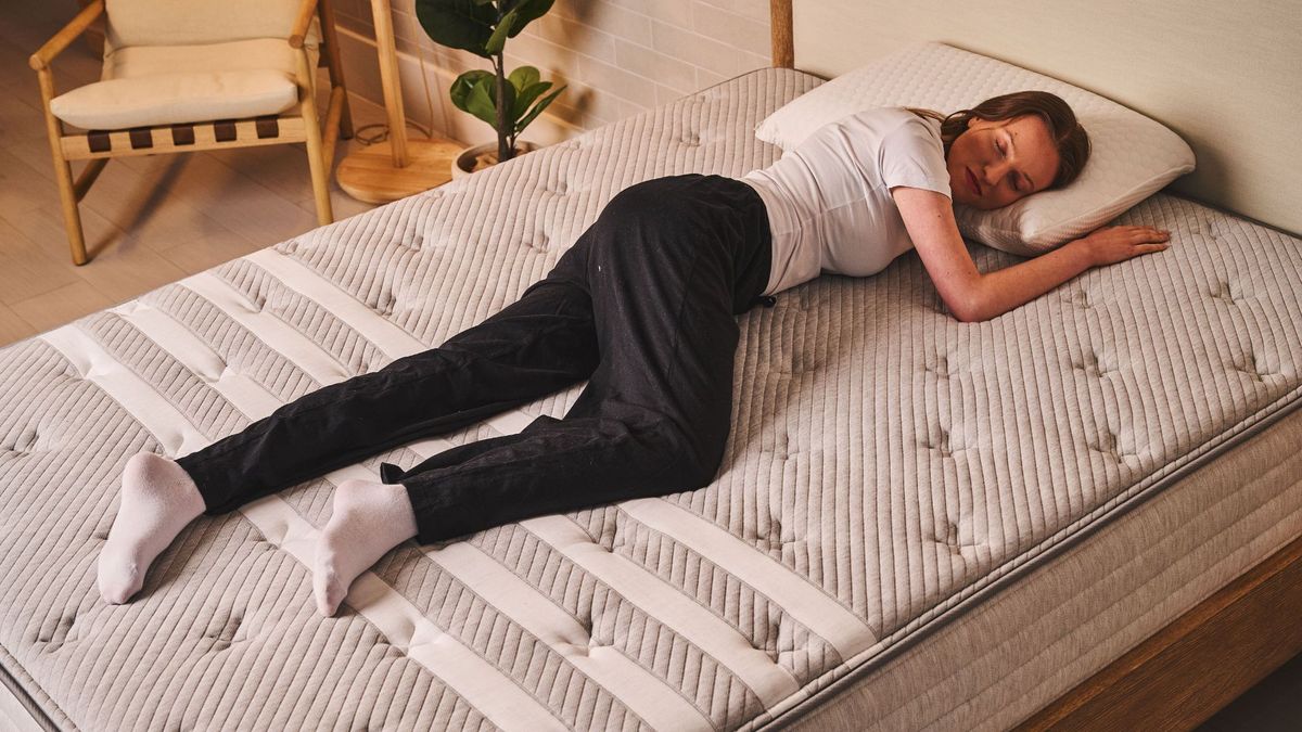A woman sleeps on her side on the Leesa Studio Chill Mattress