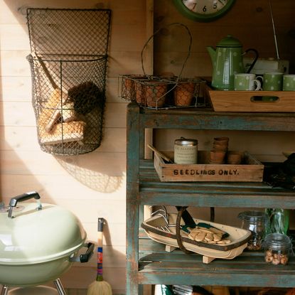 wooden shed with shelf and bbq stand