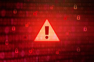 A red warning sign on a backgroud of code, denoting malware and cyber attacks