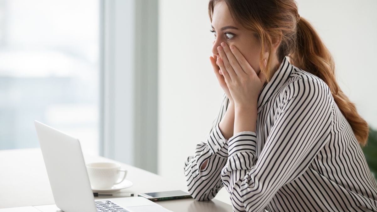 Shocked woman worker looking at laptop screen