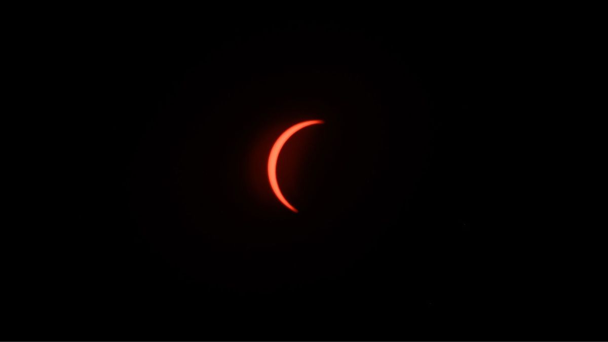 The eclipsed sun is photographed in a black sky during the partial phase of a total solar eclipse.