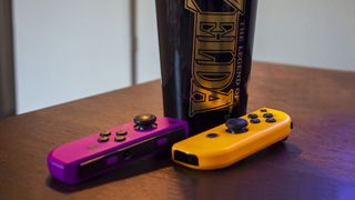 Nintendo Switch Joy-Con Purple and Orange next to Zelda cup