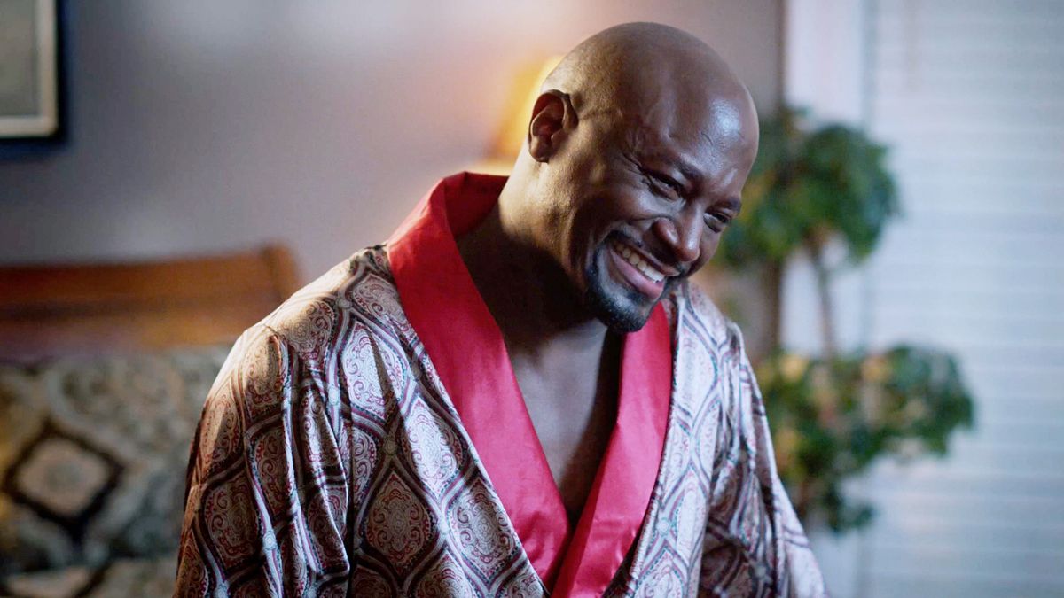 Taye Diggs as Lance smiling in a robe in Love &amp; Murder: Atlanta Playboy