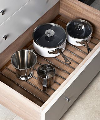 Metal pan stand and saucepans in a drawer