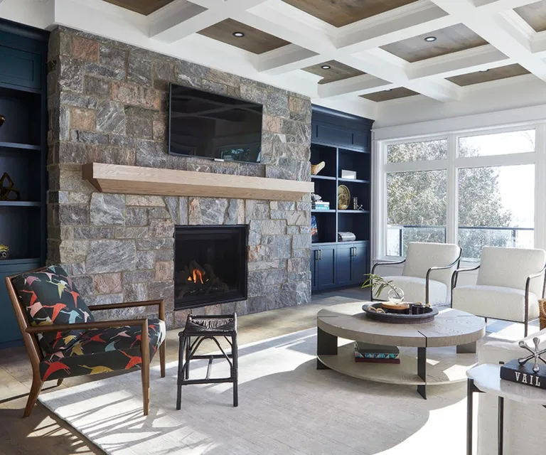 Living room with stone fire place blue alcove furniture and white armchairs around a coffee table