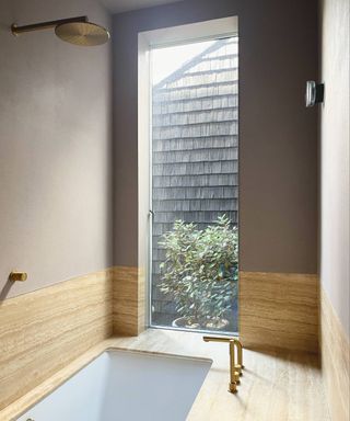 sunken bath with wood cladding and plastered painted walls, large glass window