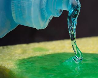 how to remove grease stains - washing up liquid dish soap on a sponge - GettyImages-750557307