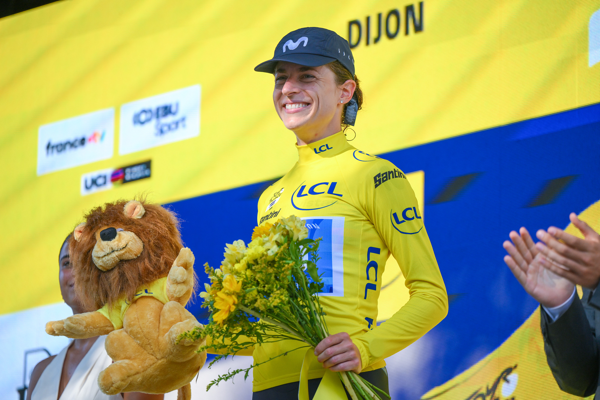 Marlen Reusser in the yellow jersey holding flowers on the Tour de France Femmes podium