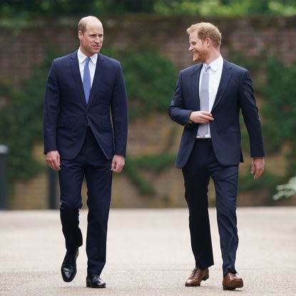 Prince William wearing a suit walking with Prince Harry at Kensington Palace