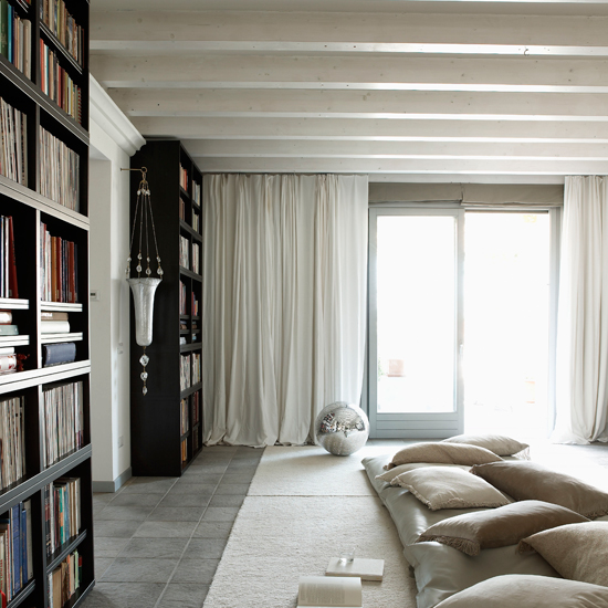 attic living area with white curtain and book shelf