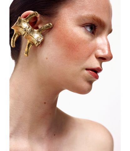 Woman wearing oversized gold earring