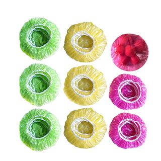 A set of circular food covers in green, yellow and pink
