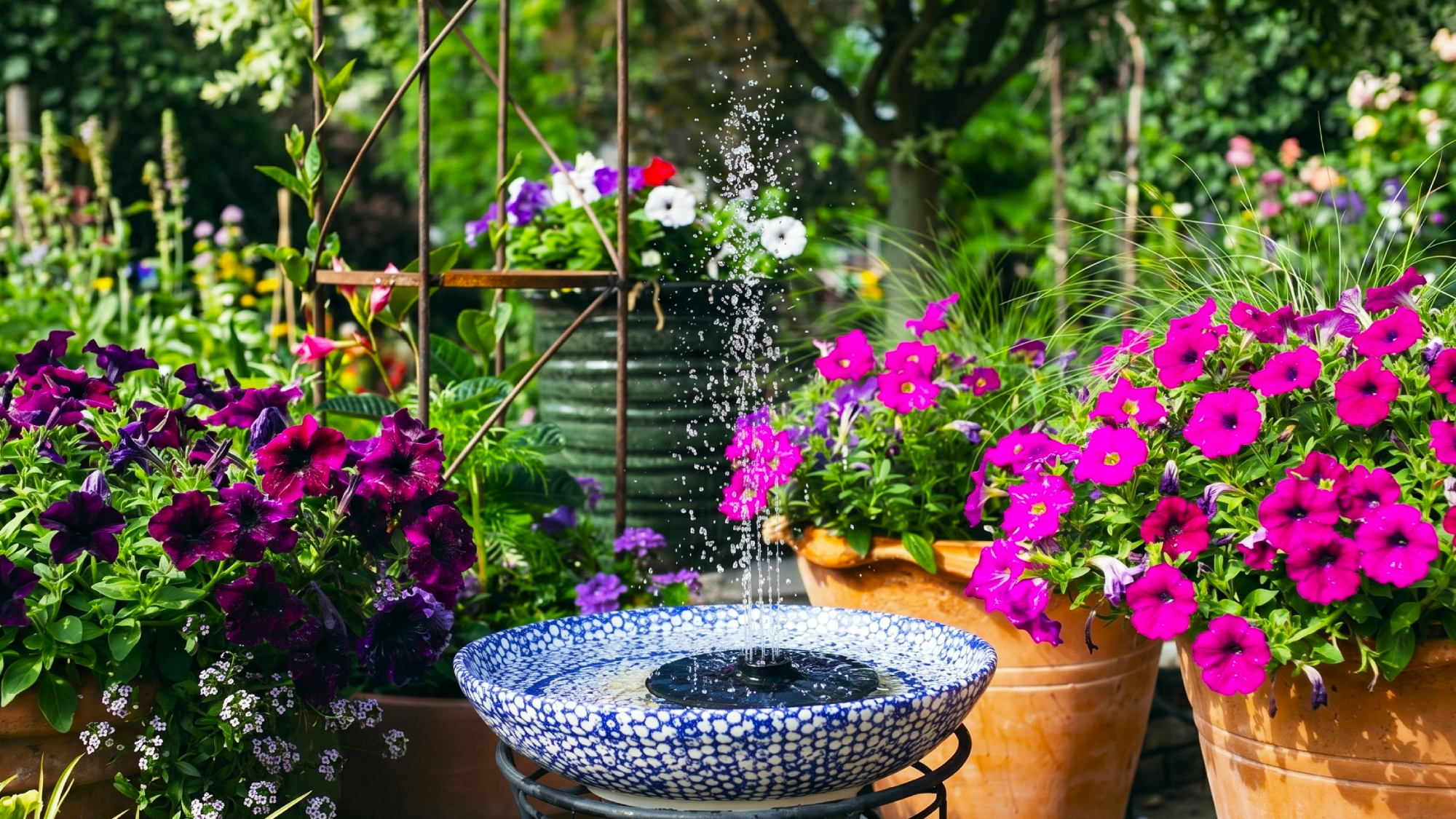 Garden water feature made from a container and a solar powered floating water fountain